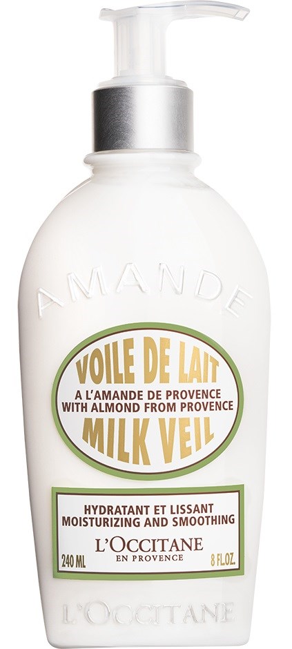 En hvit lotionflaske med pumpe, merket som mandel og melk teppe fuktighetsgivende og jevnet ut fra L'Occitane.