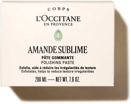 En vit låda med svart text som visar L'Occitane Amande Sublime Polering Pasta, 200 ml, Hjälper till att minska texturavvikelser.