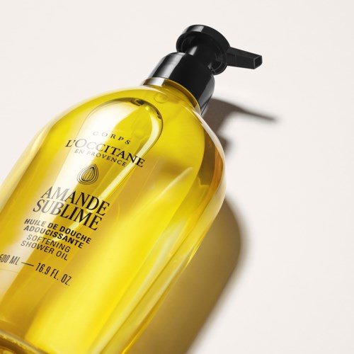 L'Occitane suihkuöljy, keltainen neste ja musta pumppu, etiketti näyttää tuotteen tiedot ja brändin.