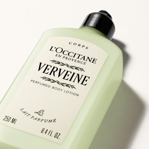 En lys grønn flaske med duftende kroppslotion og svart lokk, merket VERVEINE av L'OCCITANE.