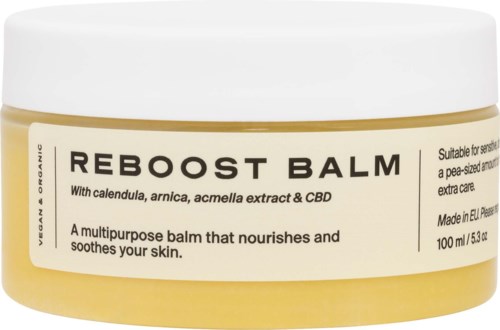 A yellow jar of Reboost Balm with white lid, labeled with ingredients and uses for skin nourishment and soothing.
