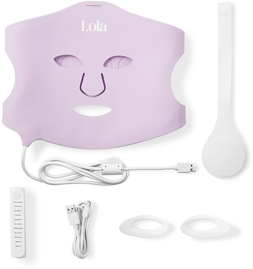 Ett rosa ansiktsmask med öppningar för ögon och näsa, en vit spatula, laddare och tillbehör för hudvård eller ansiktsbehandling.