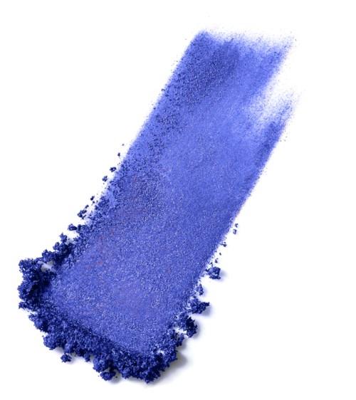 A rectangular block of blue eyeshadow with powder scattered around. It has a slightly dusty appearance.