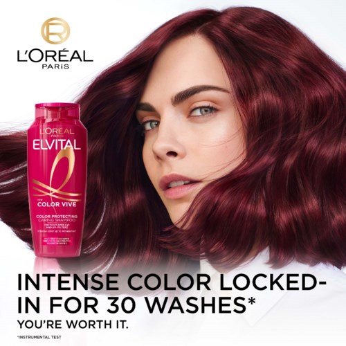 En kvinna med glänsande, rött hår bredvid en rosa flaska hårfärg från L'Oréal Paris. Texten främjar hårfärgbeskydd i 30 tvättar.