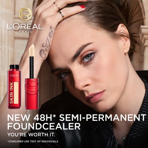 A woman with makeup, tattoos, and a serious expression, next to L'Oréal skin ink semi-permanent foundation advertisement.