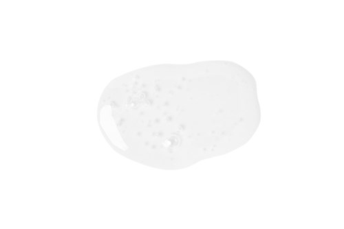 A clear, oval-shaped soap with bubbles inside sits on a white surface.