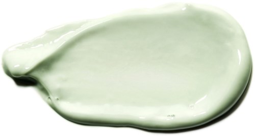 En ljusgrön kräm eller lotion som spreadats ut, med en slät, glansig yta.