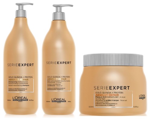 Three hair care products in orange containers, two with pumps and one with a screw lid.