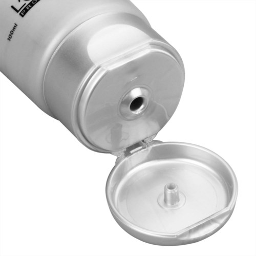 En vit tub med ett lock som kan öppnas och liten öppning, troligen en behållare för kräm eller gel.