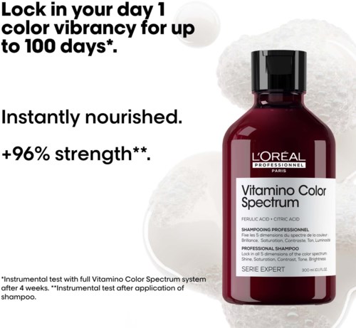 En rød shampoo-flaske med hvid og sort label, specialshampoo til farvet hår, med hvid tekstureret baggrund.