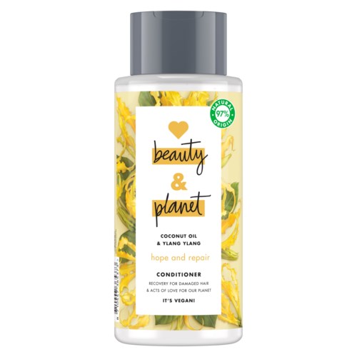 En flaska balsam med gula blommor och gröna blad, märkt 'beauty & planet' för hårreparation.