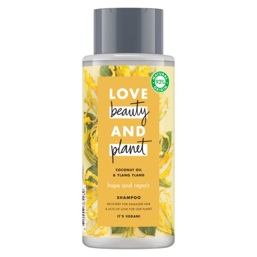 En schampo-flaska med gul och grönbladig design, märkt "Love, Beauty, and Planet" för skadat hår.