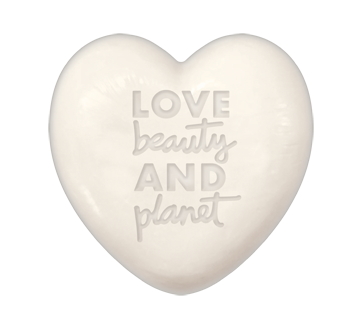 Et hvitt hjerteformet objekt med ordene: 'LOVE beauty AND planet' inngravert.