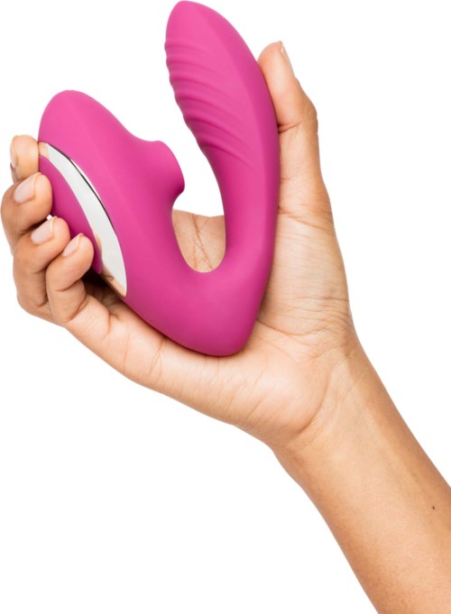 En hand håller en rosa, U-formad vibrator med en texturerad sida och en vit knapp på.