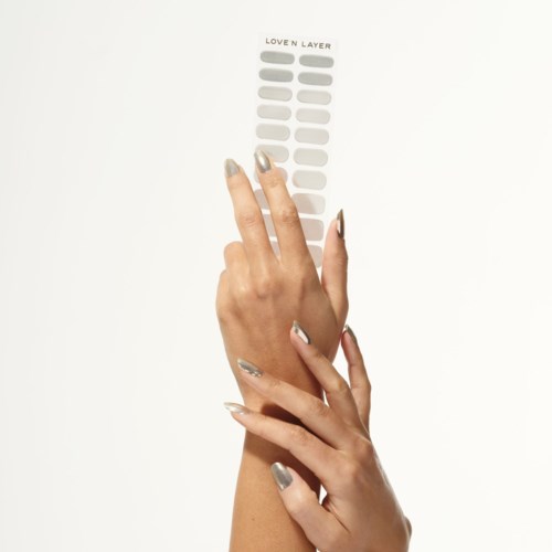 En hand håller ett fingerprov med olika färger märkt 'Loven Layer' som visar olika nagellackfärger.