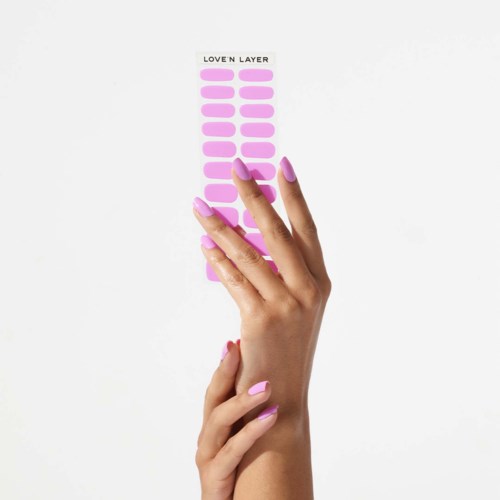 A hand with pink nails points to a sticker sheet labeled "LOVE N LAYER".