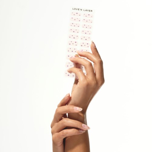 A hand holds a small, patterned strip with tiny hearts and dots, labeled "Loven Layer" at the top.