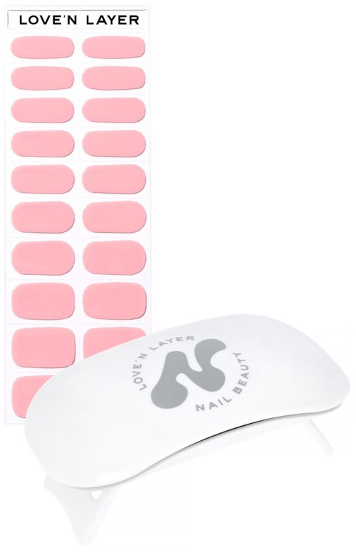 Nagellacksticker med rosa 'love'n layer' design och ett vitt nagelverktyg med samma varumärke.