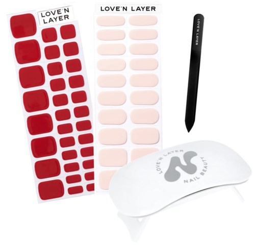 Nail art tools including stickers, a black manicure stick, and a UV lamp with the brand 'Love'n Layer'.