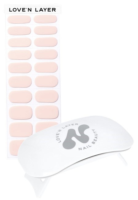 Ett nagelvårdsset med rosa nagellappar och en kurvad enhet, märkt 'LOVE'N LAYER' och 'NAIL BEAUT'.