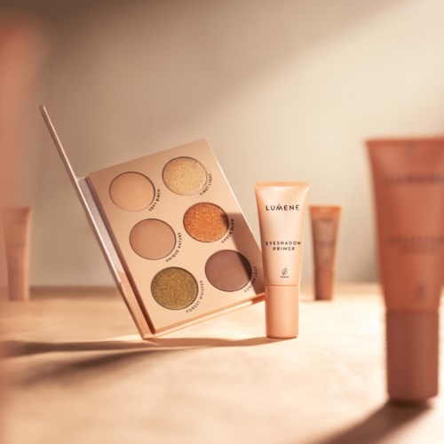 Ein Lidschattenpalette mit sechs Farben und eine Tube mit Lumene Eyeshadow Primer auf einer Holzoberfläche.