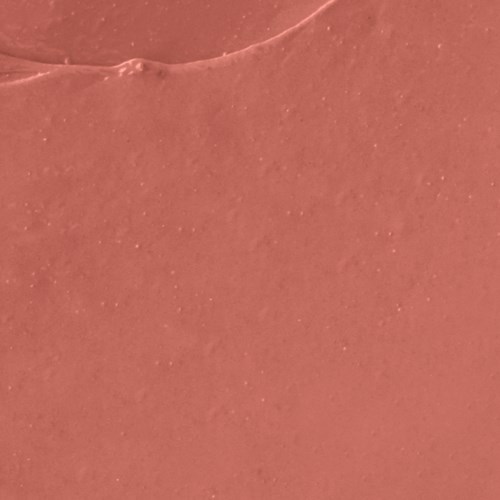Close-up of a pinkish-orange surface with tiny sparkles and a small bump or mark.