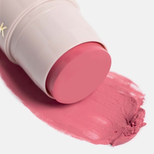 Ett rosa läppstift visas med sin färg utspridd på en vit yta.