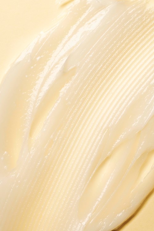 Kermainen, sileä, kiertyvä aine, todennäköisesti voi tai margariini, kiiltävä pinta ja vaaleankeltainen väri.