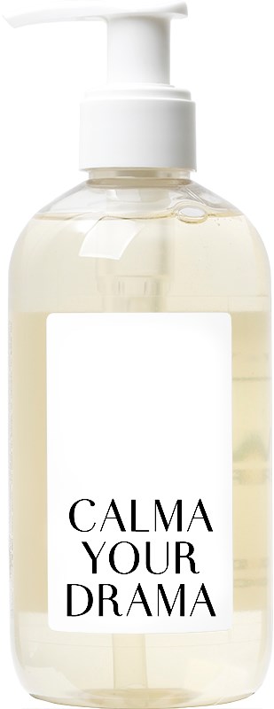 En klar flaske med hvit pumpe, merket "CALMA YOUR DRAMA," sannsynligvis en lotion- eller såpedispenser.