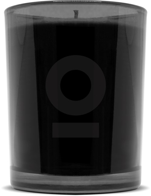 En svart ljus i ett glas med en enkel etikett.
