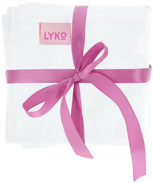 Et stykke hvit stoff er knytt med et rosa bånd, med en rosa etikett som det står LYKO på.