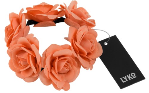 Ett korallfärgat blomhalsband med stora, mjuka rosor. Ett svart etikett är fäst vid bandet.
