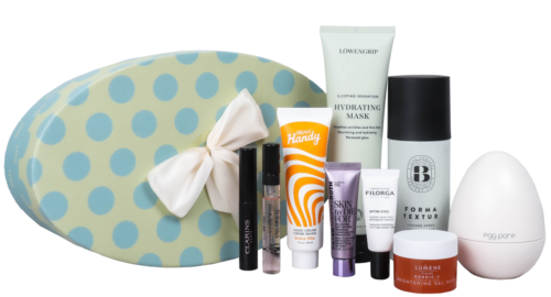 En samling hudpleie- og sminkeprodukter med en makeup-veske med polkadotmønster og sløyfe.
