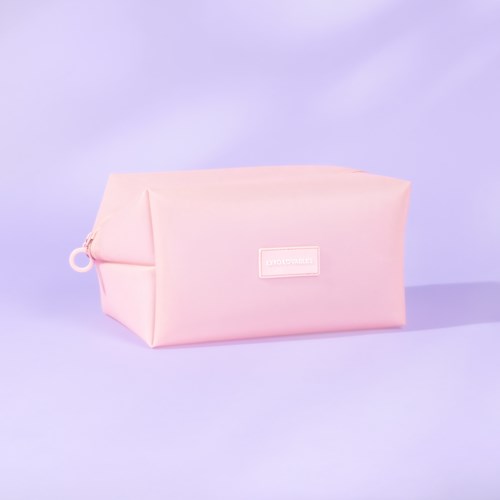 Ett mjukt rosa förvaringspås med dragkedja och liten etikett på lila bakgrund.