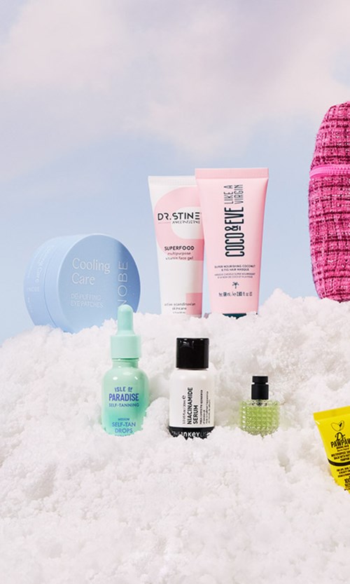 Ulike hudpleieprodukter plassert på snø, inkludert kremer, serum og et lite gult element, med en rosa vevd ting i nærheten.