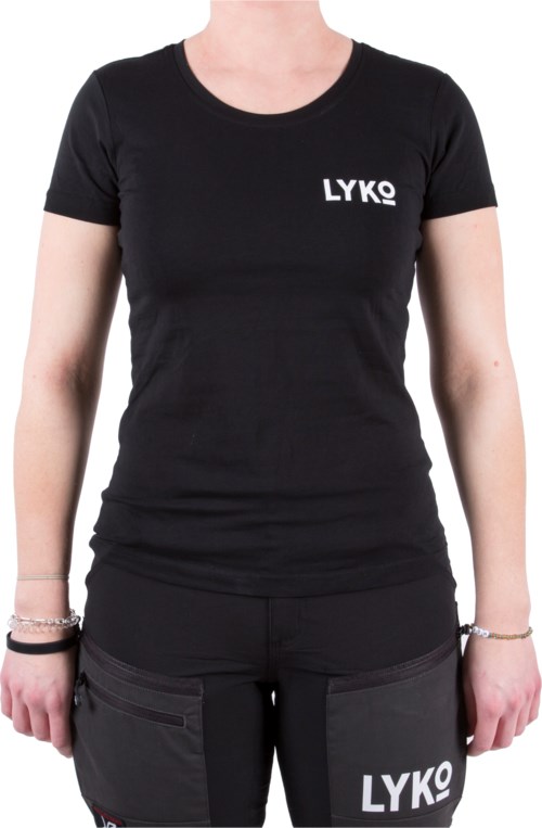 En kvinne har på seg en svart T-skjorte med 'LYKO' på øverst til venstre, og mørke bukser med 'LYKO'-lapper. Hendes armer er synlige.