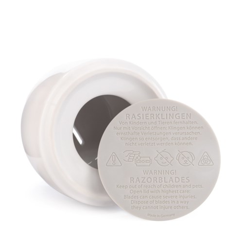 A white container with a warning label about razors, warning children and pets to keep it away.