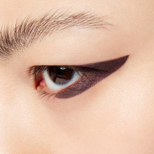 Close-up van een oog met zwarte eyeliner en natuurlijke huid. Wenkbrauw en wimpers zichtbaar.