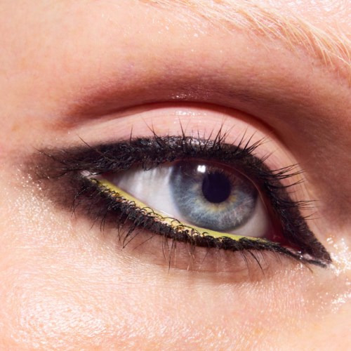 Close-up van een blauw oog met make-up, inclusief eyeliner en oogschaduw, met gedetailleerde wimpers en huidtextuur.
