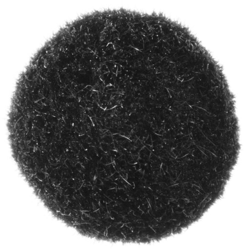 En svart lurvig boll med många små strån och fibrer, rund form, ser mjuk och tät ut.