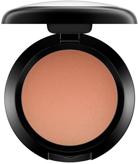 Een ronde make-upcompact met beige poeder en een zwarte deksel.