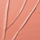 Två flytande linjer rinner ner för en rosa yta och bildar tunna, glänsande streaks.