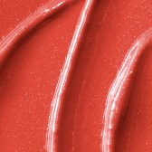 Close-up of reddish, glossy, shiny substance with smooth curves and lines, possibly a cosmetic or makeup product.