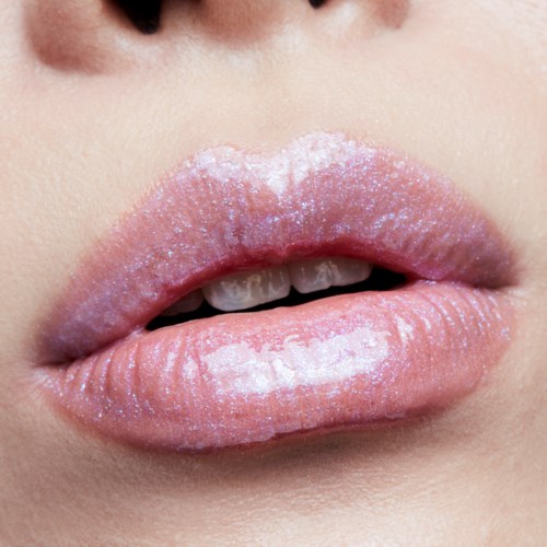 Nærbilde av lepper med rosa gloss og hvite glitrer, med tenner litt synlige mellom dem.