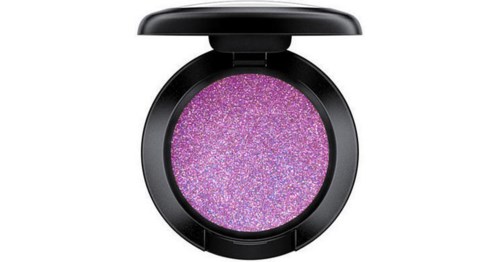En rund makeup-produkt med lila glitter inuti och ett svart lock som kan vikas upp.