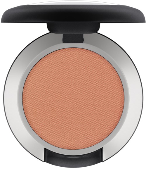 Ett runt makeup-kompakt med orange blush inuti och ett svart lock upptill.
