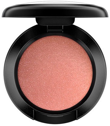 En rund makeupkompakt med rosa blush inuti och en svart lock.