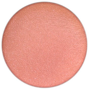En rund, persikfärgad makeuprouge med glänsande yta.