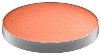 En rund orange makeup blush eller puder i en silverbehållare.