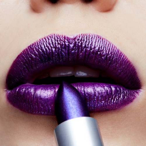 Close-up van lippen die glanzende, donkerpaarse lippenstift krijgen.